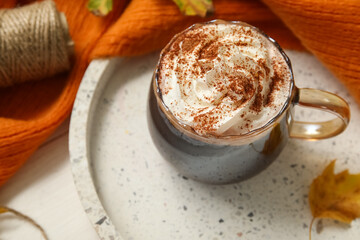 Autumn composition with cup of cocoa, scarf and tray on white wooden background, closeup