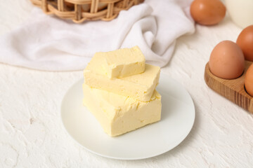 Plate with fresh butter and eggs on light table