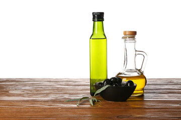 Decanter and bottle of fresh olive oil on wooden table against white background