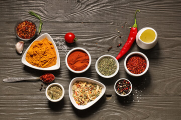 Composition with bowls of fresh aromatic spices on dark wooden background