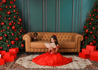 Menina lendo livro em casa na sala decorada para natal 