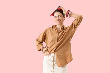 Beautiful woman with bun and scrunchies on pink background