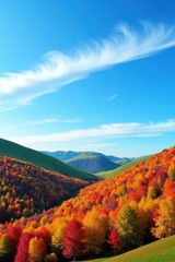 A vibrant autumn vista reveals a valley nestled amongst colorful hills, with a vibrant blue sky adorned with wispy clouds.