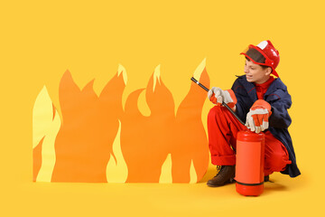 Teenage firefighter with extinguisher and paper flame on yellow background