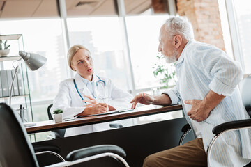 Obraz premium Senior patient consulting with doctor about health concerns during appointment in modern medical office