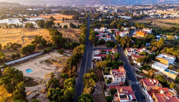 High-angle view of a city street intersecting with undeveloped land