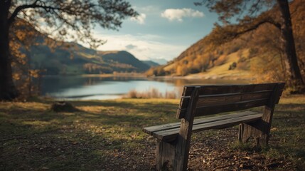 A rustic wooden park bench overlooks a serene lake nestled amongst autumnal hills.