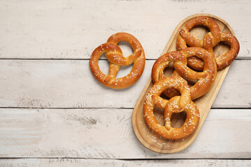Tray with tasty pretzels on white wooden background, closeup
