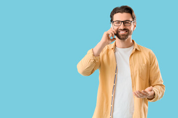 Male secretary talking by mobile phone on blue background