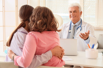 Fototapeta premium Male fertility doctor advising lesbian couple on IVF in clinic