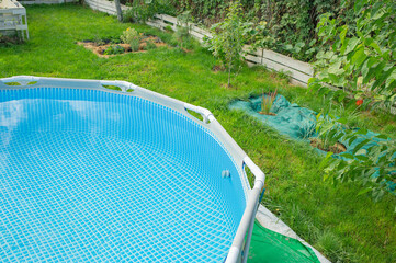 Frame pool with clean transparent water for swimming in the summer season in the garden.