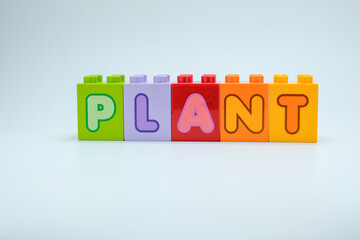 Colorful toy blocks spelling PLANT on clean white background. Perfect for education, environment,...