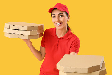 Female courier with pizza boxes on yellow background