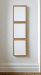 A vertical column of three stacked square light oak wooden picture frames with blank white mockup space.