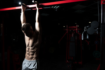 Man Performing Hanging Leg Raises Exercise For Abs