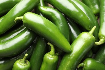Fresh green jalapeno peppers as background, closeup