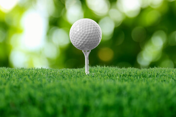Golf ball on green grass against blurred background