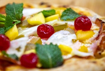 The iconic, wonderful, and unique California pizza, made with Canadian pork tenderloin and tropical fruits—pineapple, mango, fig, peach, and cherries—garnished with fresh mint leaves. 