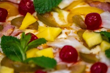 The iconic, wonderful, and unique California pizza, made with Canadian pork tenderloin and tropical fruits—pineapple, mango, fig, peach, and cherries—garnished with fresh mint leaves. 