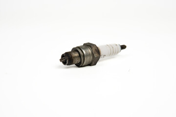 Used spark plug on white background, close-up detail of automotive engine part isolated for repair...