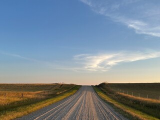 Dirt country road surrounded by autumn foliage in a rural countryside setting