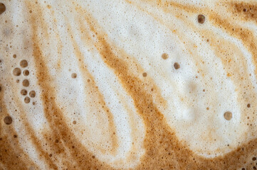 Full frame shot of the surface of hot latte coffee. A latte is a coffee drink made with espresso and steamed milk.