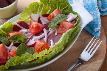 Sliced Baby Beetroot in a tomatoe and onion salad close up