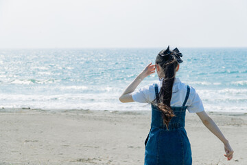 海に歩いている女性の後ろ姿