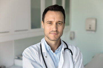 Headshot portrait male doctor looking at camera with light smile