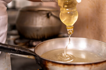 Woman pouring cooking oil in pan for frying