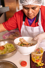 Woman preparing fried chicken in restaurant kitchen