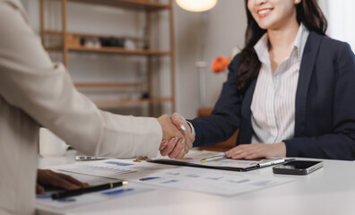 Businesswomen shaking hands after successful meeting in office