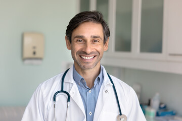 Headshot portrait mature male doctor looking at camera with smile