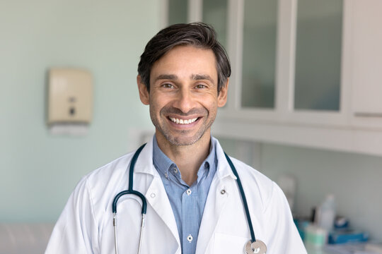 Headshot portrait mature male doctor looking at camera with smile
