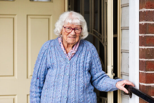 Portrait of 99 year old elderly Australian woman standing by front door of her home