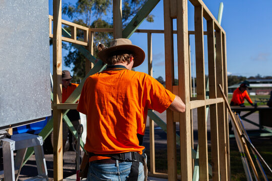 frame of ticket booth building with trade apprentice working in sunlight