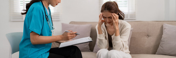 Asian Woman Mental Health Professional Provides Home Consultation for Stressed Adult Patient...