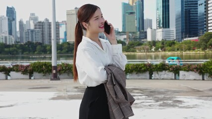 Asian Young woman confident smiling talking phone city outdoor casual business style holding jacket urban background coffee cup lifestyle urban environment vibrant energy - Powered by Adobe