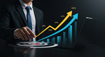 Business man pointing at target with growth charts and laptop.
