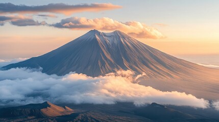 Fototapeta premium Majestic view of a snow-capped volcano at sunrise over a sea of clouds