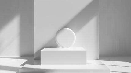 Fototapeta premium A white cube with a round white object on top, placed on a white surface with a shadowy background.