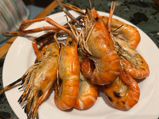 Close up view of grilled prawns on a white plate