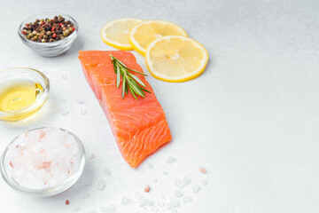 Fresh salmon fillet with lemon slices and seasonings ready for cooking