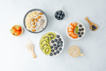 Oatmeal breakfast bowls with fruits and grains on white surface