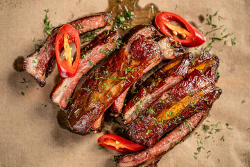 Grilled pork ribs with chili pepper and herbs top view