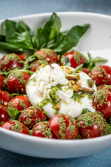 Closeup Italian burrata salad with cherry tomatoes and pesto