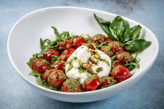 Italian burrata salad with cherry tomatoes and pesto