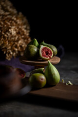 Fresh Figs Still Life.A moody still life photograph of fresh, ripe figs. The dramatic lighting creates a classic, autumnal atmosphere.
