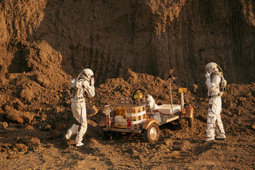 Two astronauts with a Mars rover stuck on hilly terrain during planetary exploration. © Tetiana Tuzyk