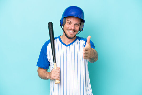 Baseball player with helmet and bat isolated on blue background shaking hands for closing a good deal